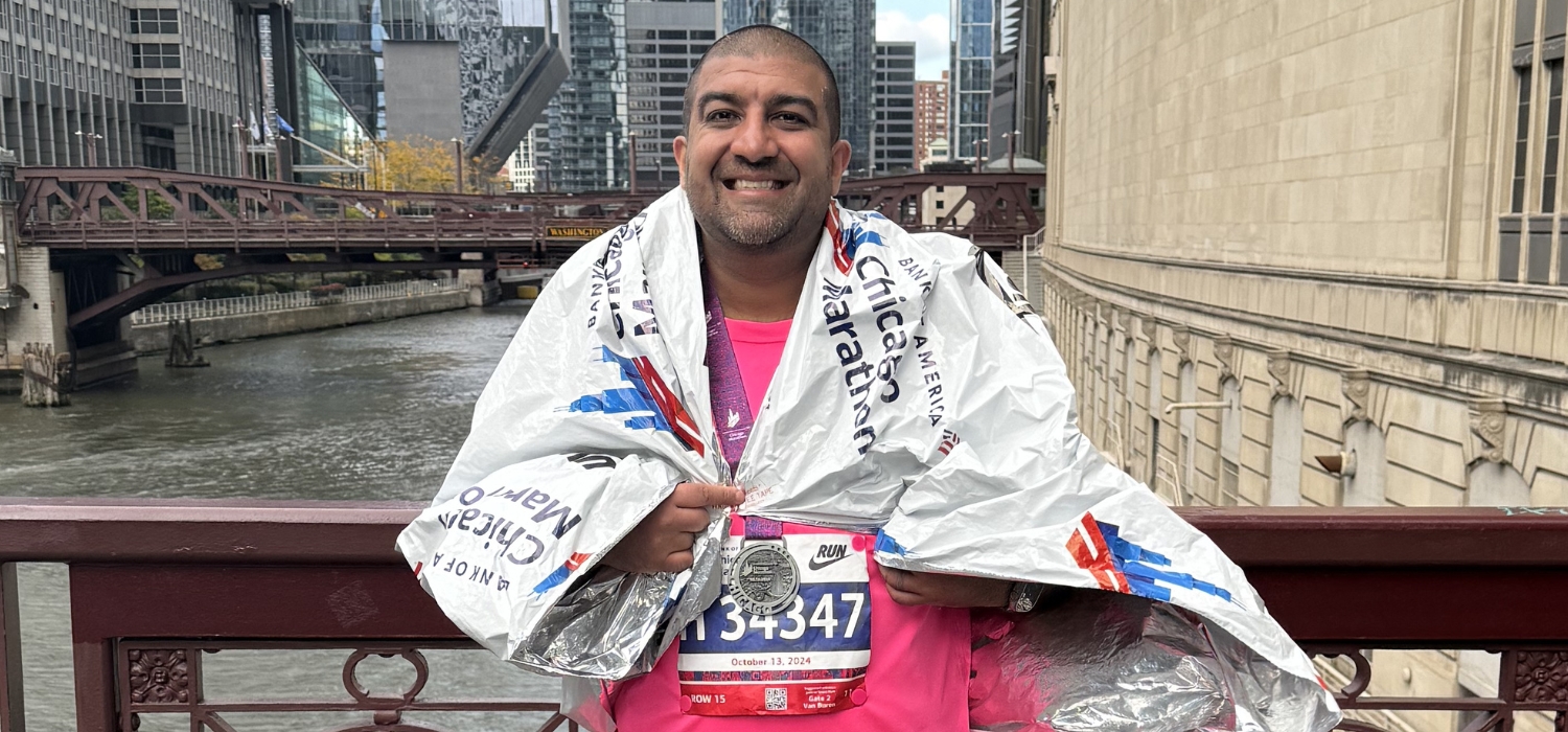 Man is wearing a towel around his shoulders after finishing the Chicago Marathon. 